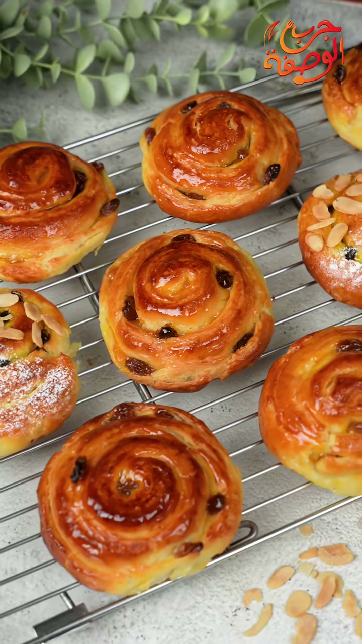 Golden baked chnek, raisin and almond-topped, on a cooling rack