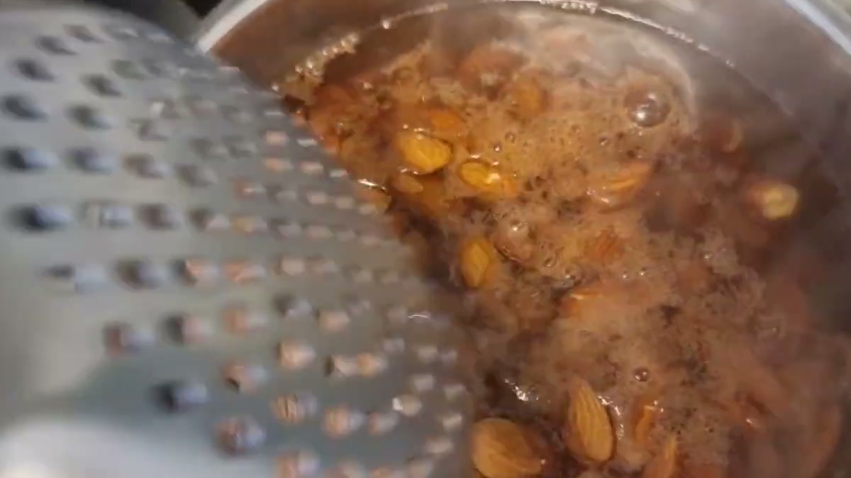 Draining almonds after blanching them in boiling water