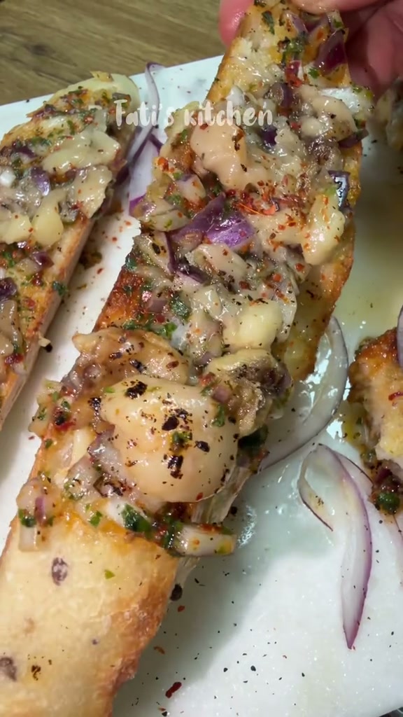 Close-up of a bone marrow toast with melted marrow, red onion and chili