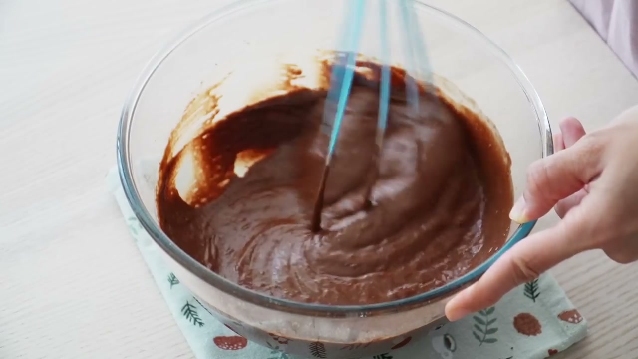 Smooth chocolate cake batter in a glass bowl