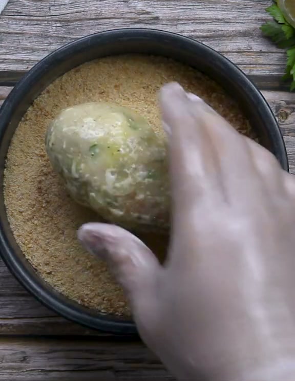 Rolling the shaped croquette in breadcrumbs