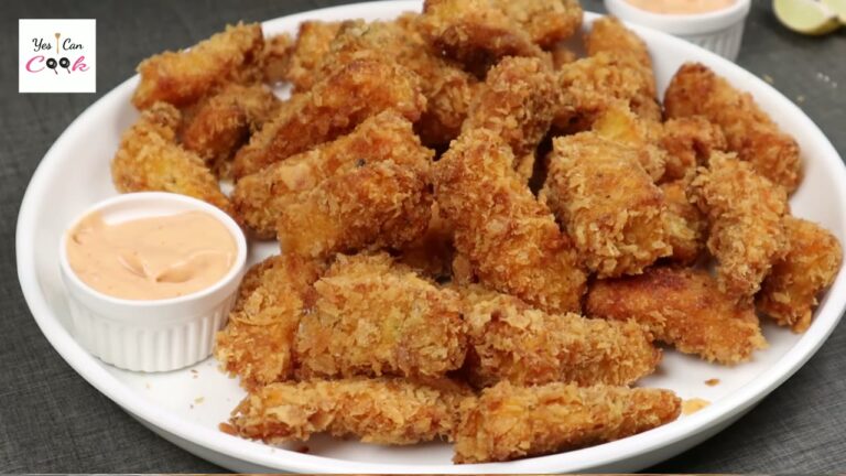 Crispy breaded fish fingers on a white plate with a pink dipping sauce
