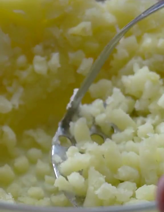 Mashing boiled potatoes for the croquette filling