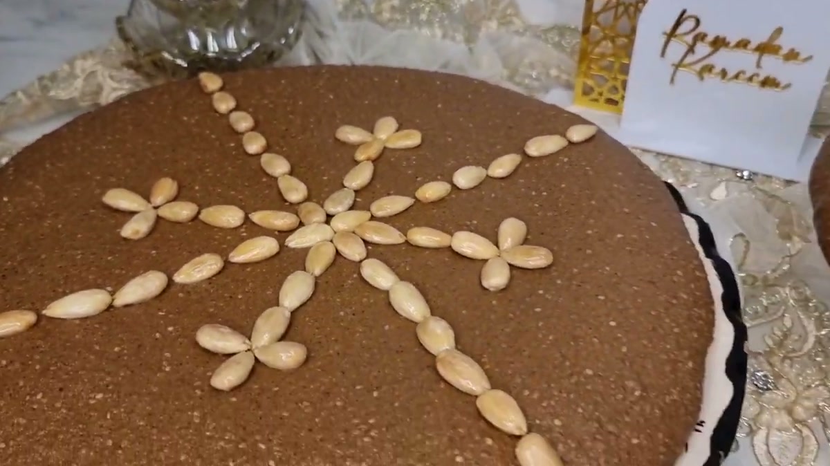 Moroccan sellou shaped into a round cake and decorated with a star of blanched almonds