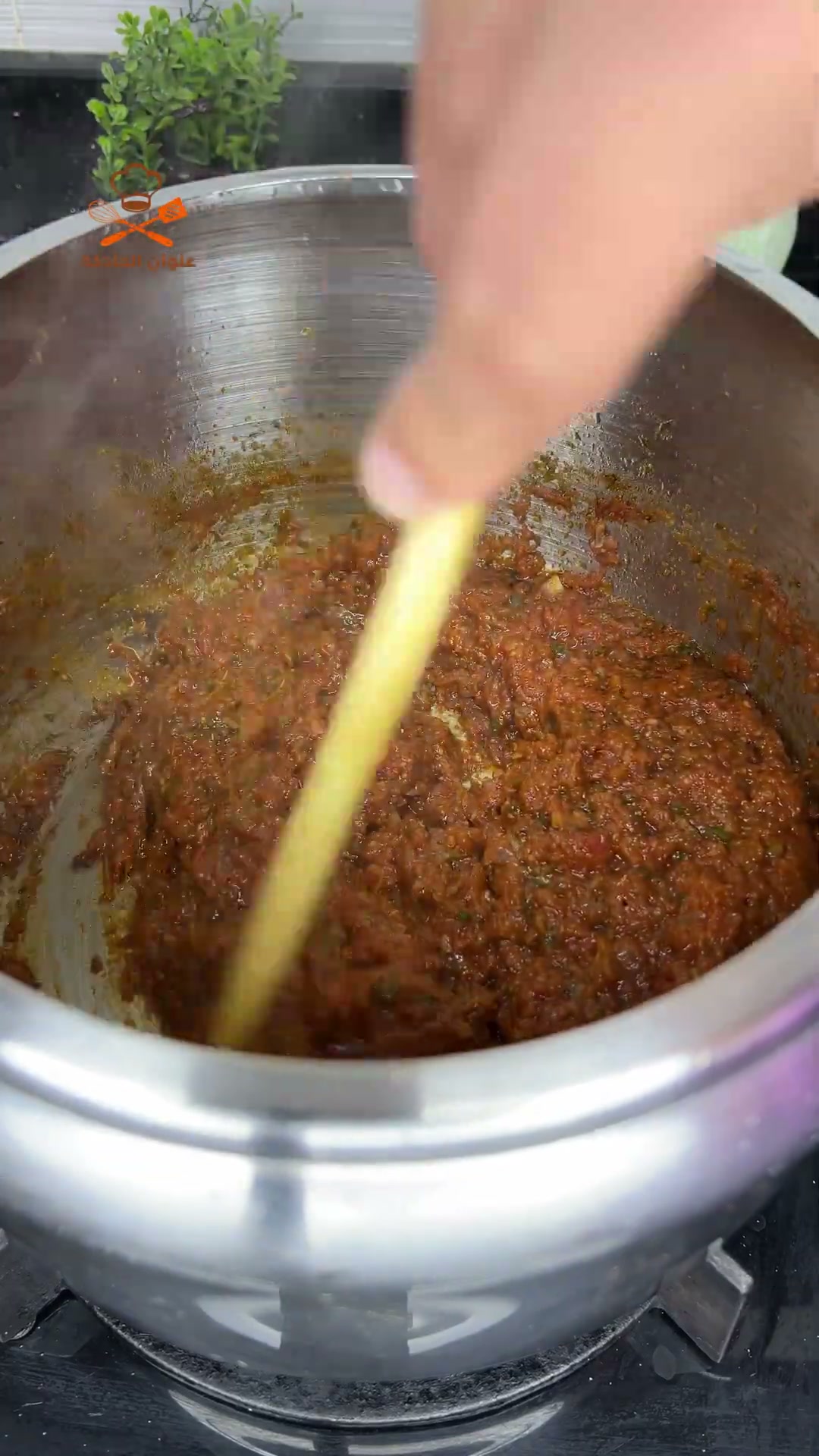Stirring the thick, reduced tomato and meat sauce until it starts to brown