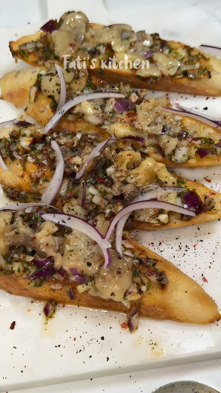 Roasted bone marrow toasts topped with red onion relish and sliced red onion