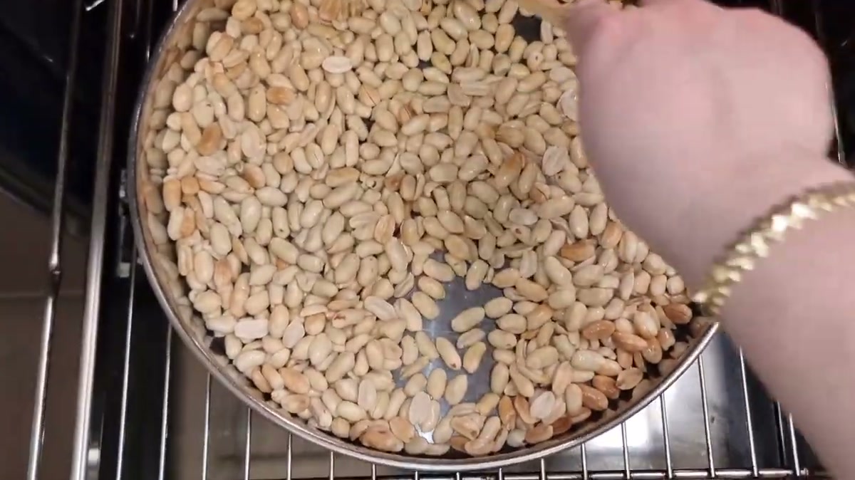 Stirring peanuts as they roast in the oven