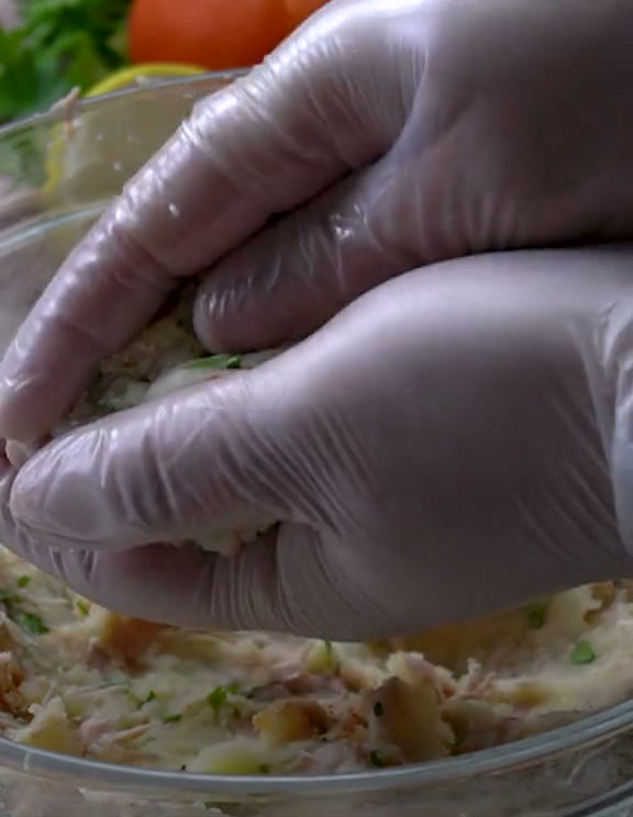 Pressing the potato and chicken filling around the drumstick bone